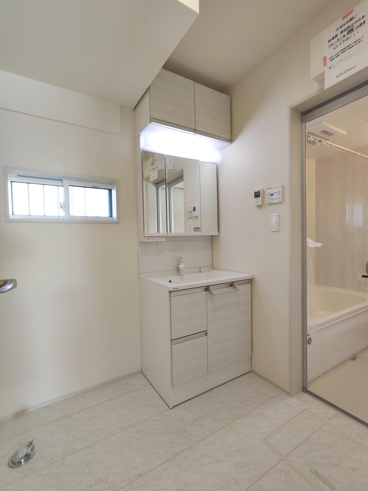 【2号棟】　ホワイトカラーでまとめられた洗面所は、横幅750mmの三面鏡付きで朝の身支度もラクラク。吊り戸もあり収納スペースにも困りません。