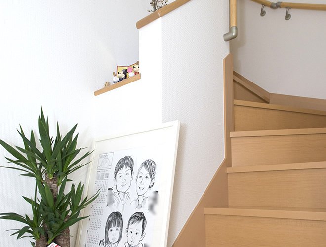ご家族の似顔絵が飾られた階段。手摺りの横のスペースにはミッキーの雛人形が。