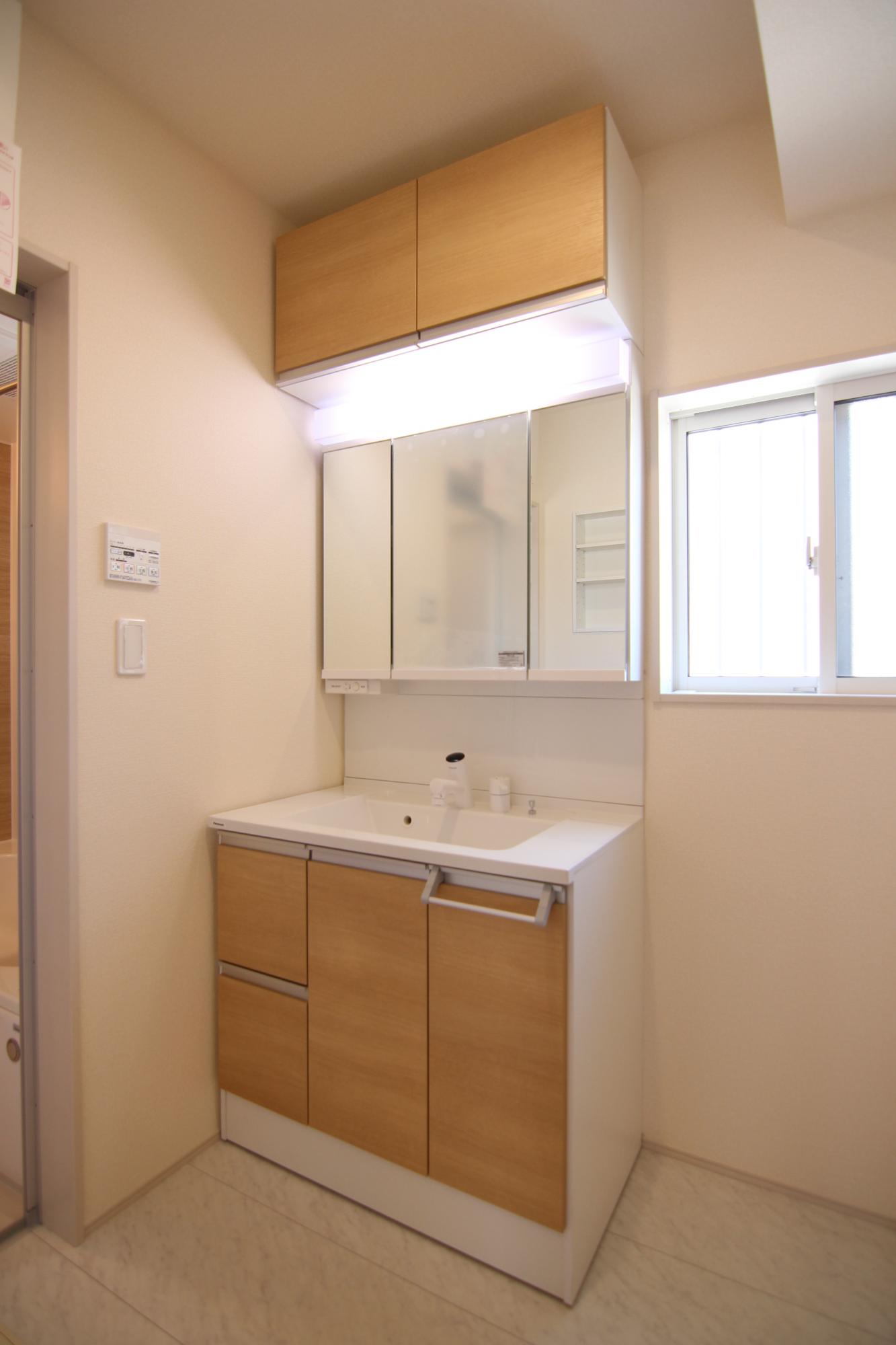 1号棟　洗面所収納　洗濯機置き場の横には便利なカウンターがあり、洗面所には収納スペースと床下収納があります。