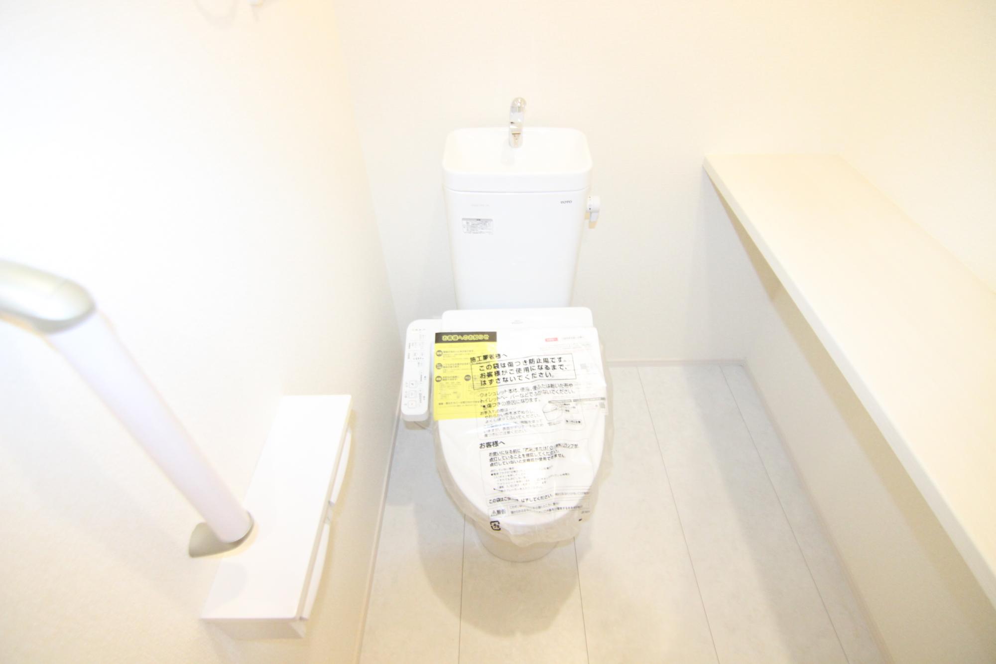 9号棟トイレ　カウンターや手すりのあるトイレ　床は水濡れに強い素材となっています