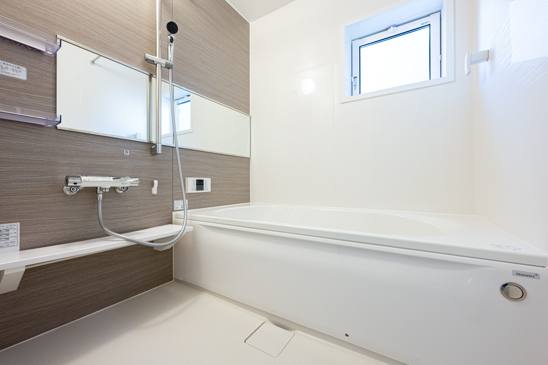 6号棟浴室　アクセントパネルを施した落ち着いた空間で、日々の疲れを癒すことができます。自然換気にも役立つ、小窓を設けています。