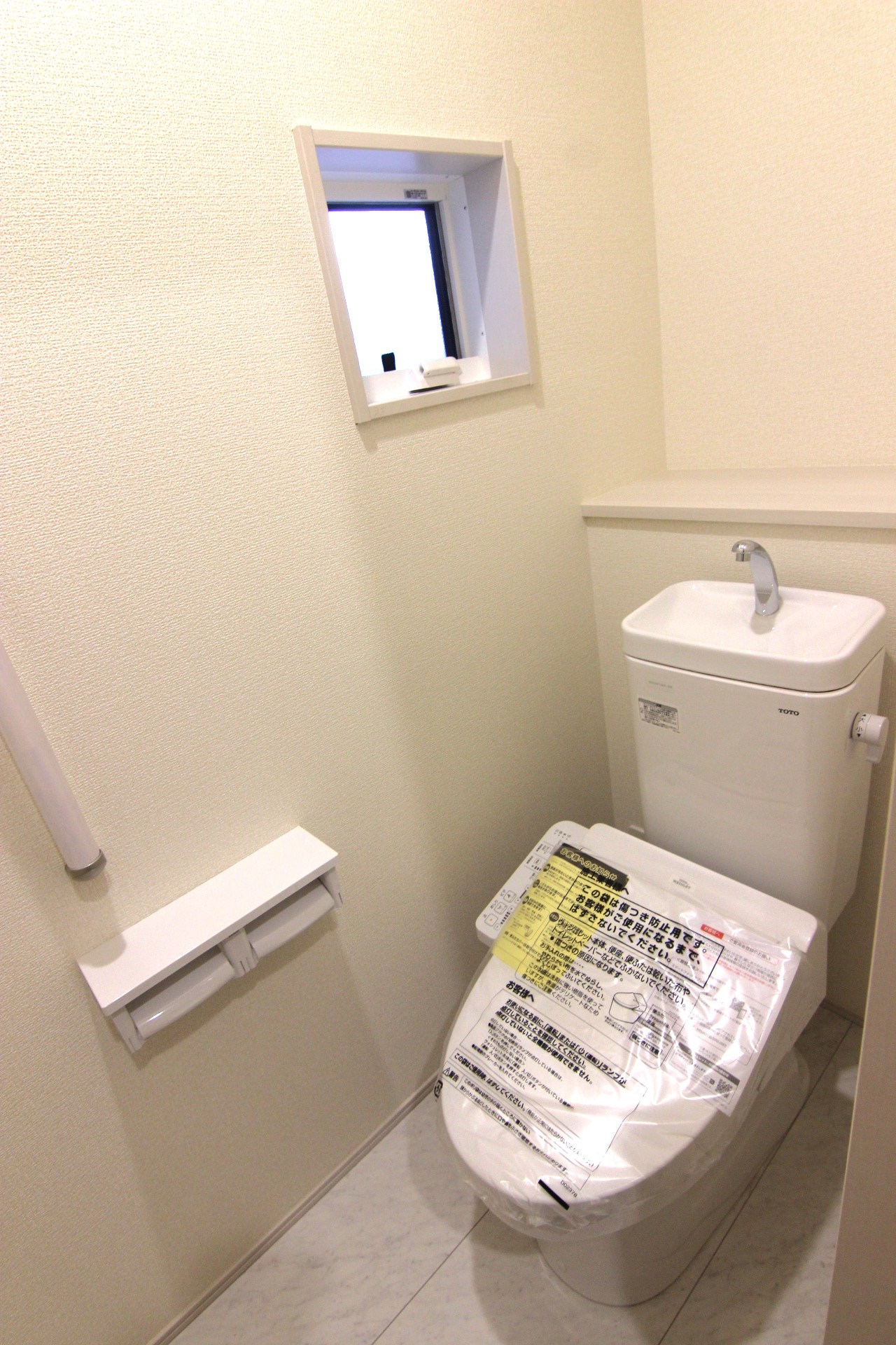 【8号棟:1階トイレ】　多機能ウォシュレット・手摺り・壁面収納付き・背面には小物が置けるカウンターも付いています。※トイレの仕様は全棟共通です