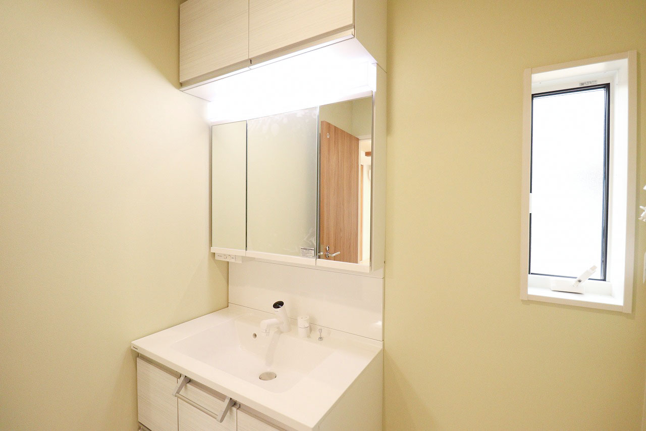 11号棟　洗面所　　三面鏡&シャワー水栓付きで朝の身支度もスムーズに行えます。上下に収納が有り、リネン類などを収納可能です。