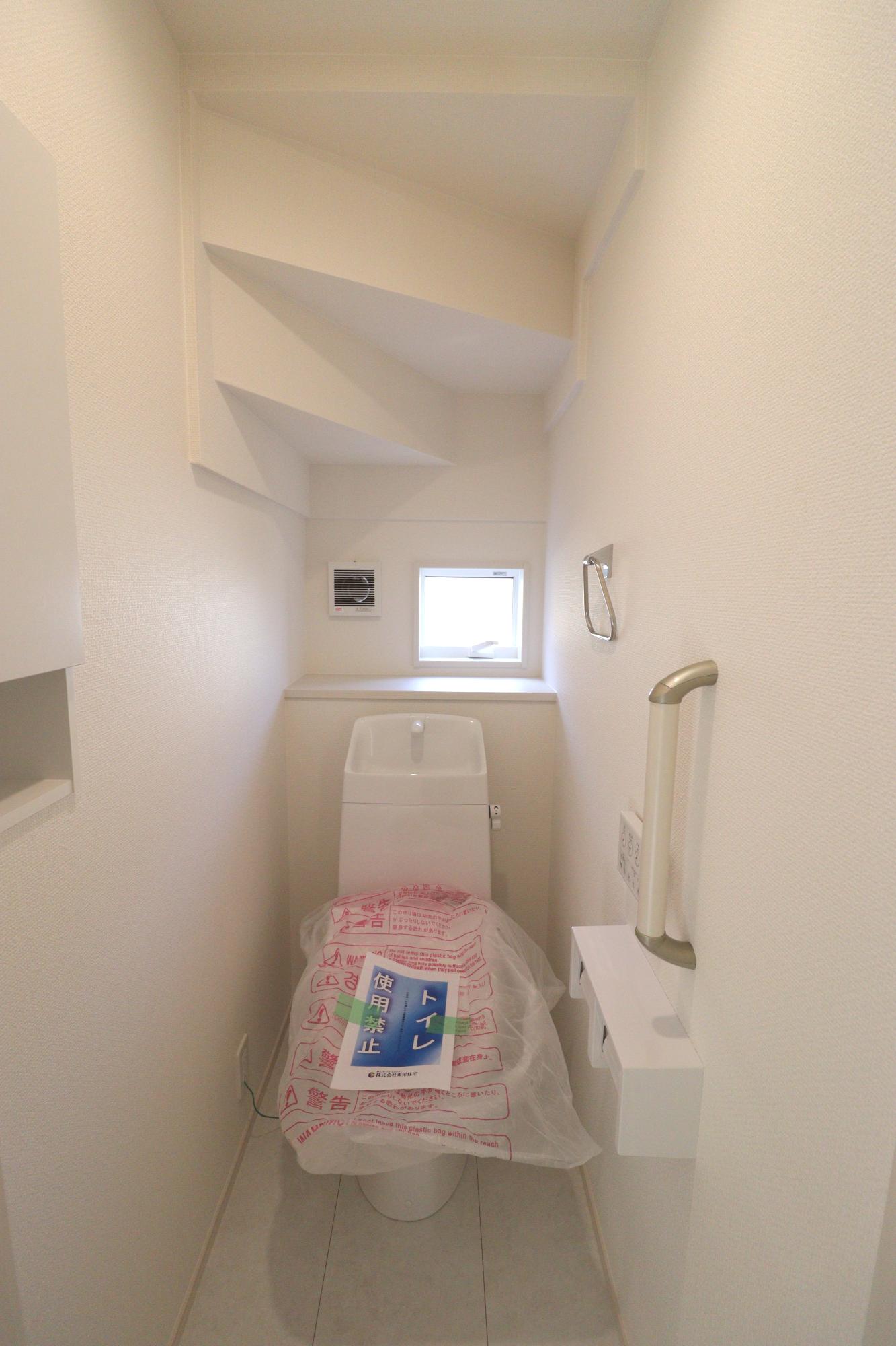 【1号棟】トイレ1階　階段下を有効活用したトイレには、トイレットペーパーが入るサイズの壁収納もございます。
