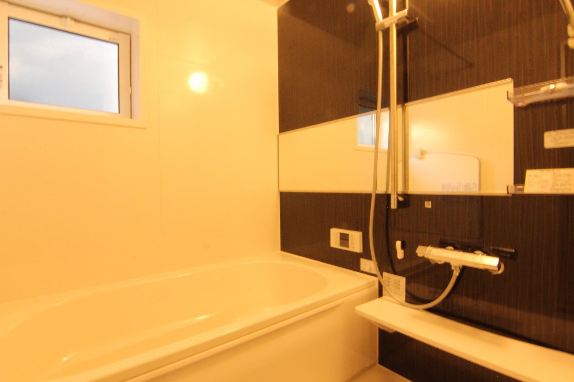 2号棟浴室 一日の疲れをゆっくりと癒していただける浴室。シャワーの高さを調節したり、手摺りとしても使用したりできるスライドバー付きです。小窓があるので、入浴後や清掃時に自然換気が可能。