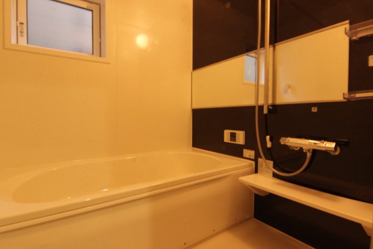 1号棟浴室 ダークカラーのアクセントパネルを施した浴室です。浴室換気乾燥機付きで、季節や天候に左右されずに洗濯物を乾かすことができ、便利です。