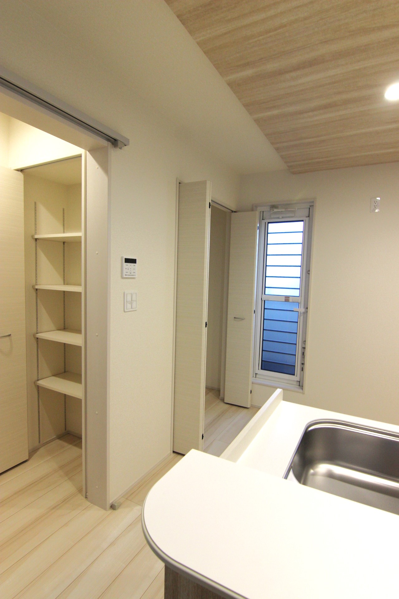 【3号棟:キッチン横収納】　キッチンのすぐ隣の階段スペースに可動式4段棚がついています。