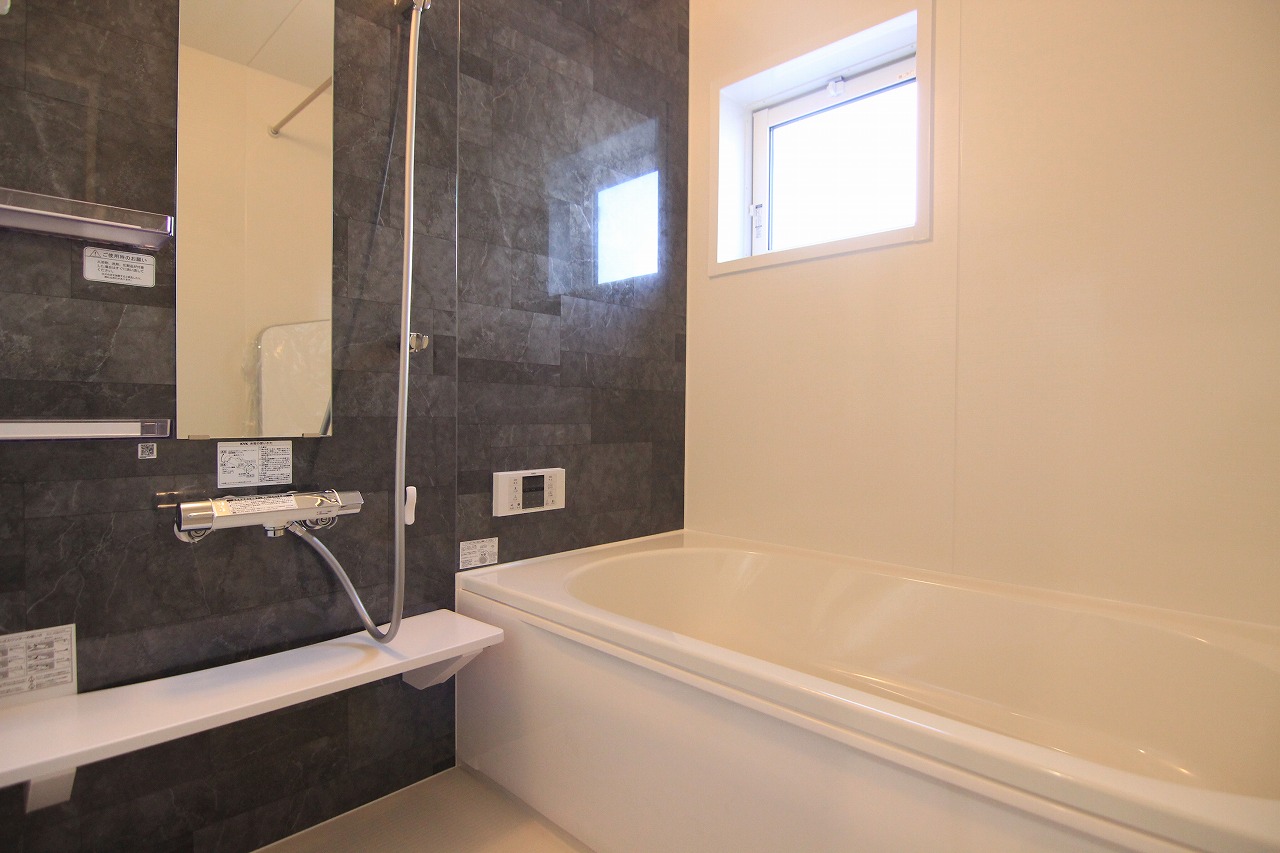 【浴室】　浴室はスタイリッシュな印象を与える、ダークカラーのアクセントパネルをセレクト。雨の日でも洗濯物を乾かすことができる、浴室乾燥機付きです。