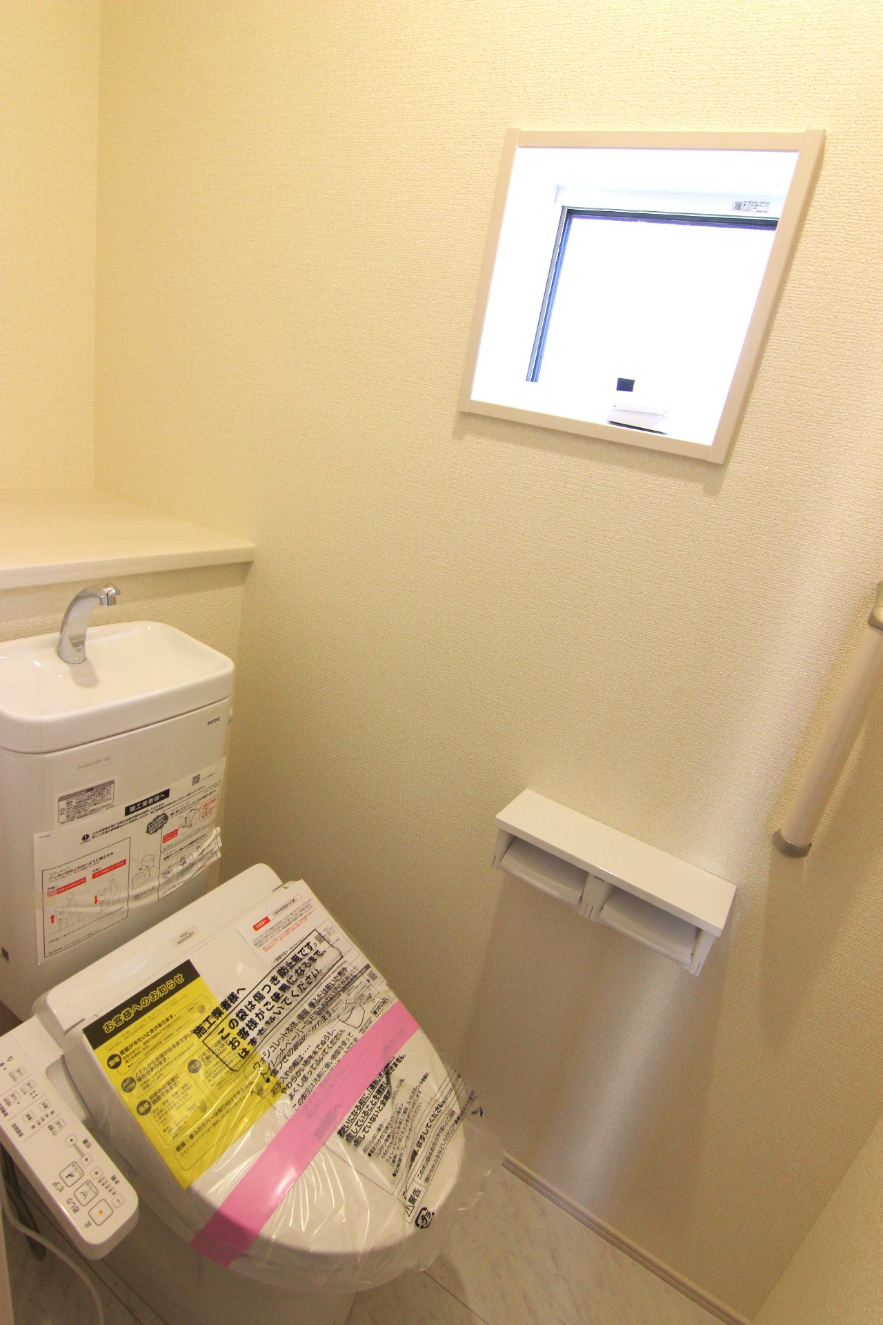 【2階トイレ】　多機能ウォシュレット・手摺り・壁面収納付き・背面には小物が置けるカウンターも付いています。※トイレの仕様は1・2階とも共通です