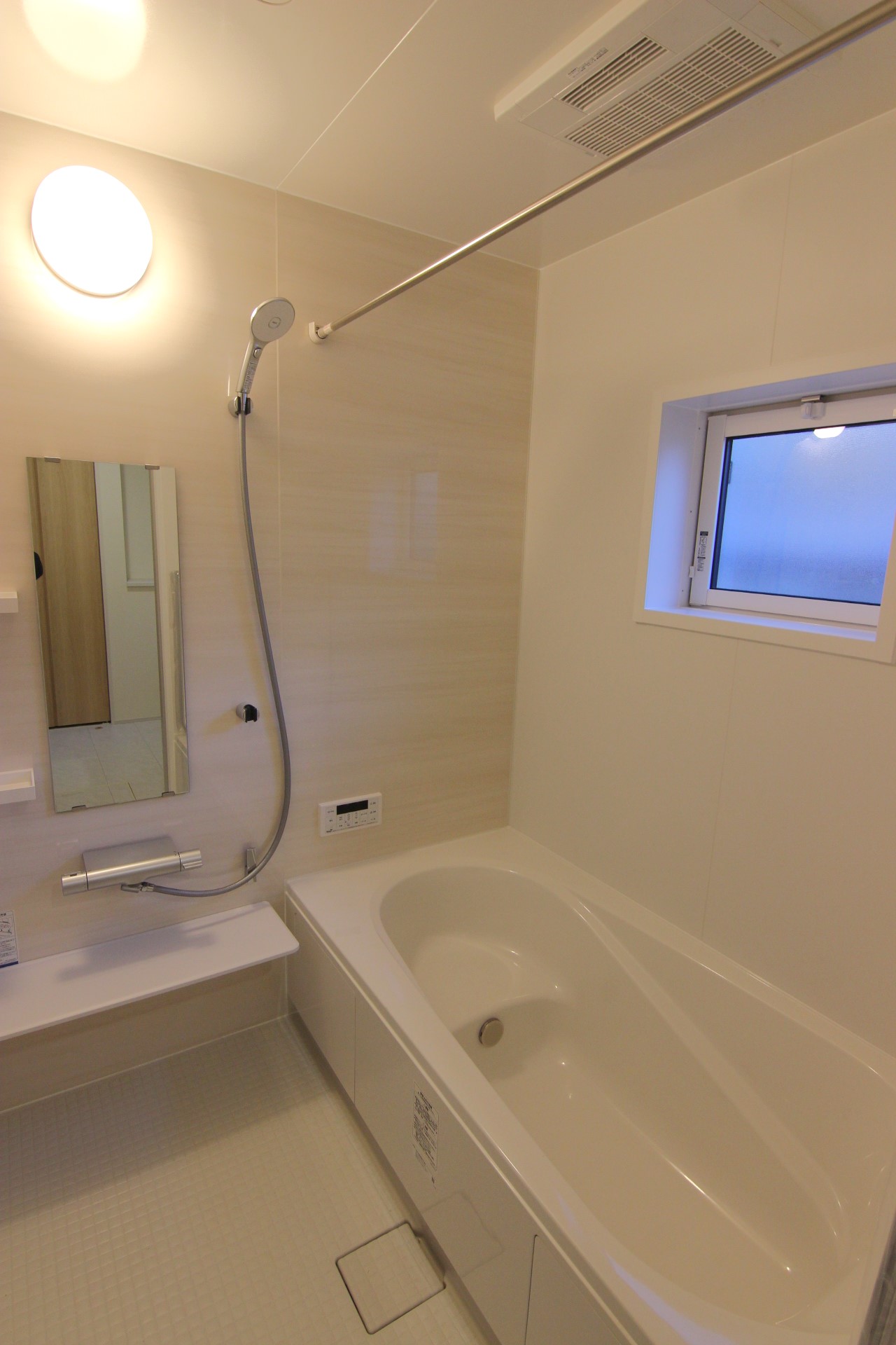 【2号棟:浴室】　白を基調とした、優しく淡い木目調の指し色がおしゃれな、明るい浴室。浴室暖房換気乾燥機・節水仕様のエコアクアシャワー・保温効果の高いサーモバスS構造の浴槽など機能面も充実。