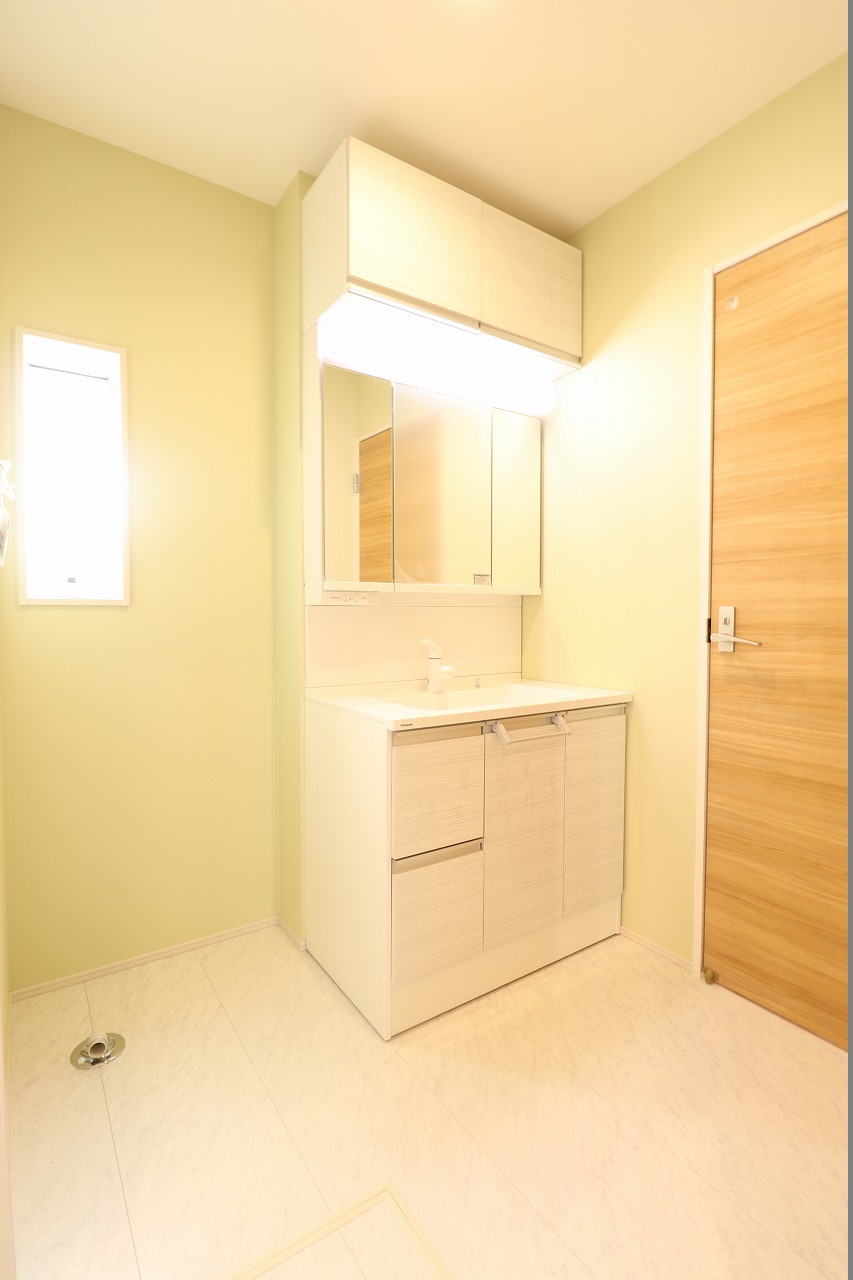 【4号棟/洗面室】　洗面室は、廊下側とキッチン側から出入り可能な2WAY仕様。家事・帰宅動線に考慮した、回遊性のある間取り設計です。