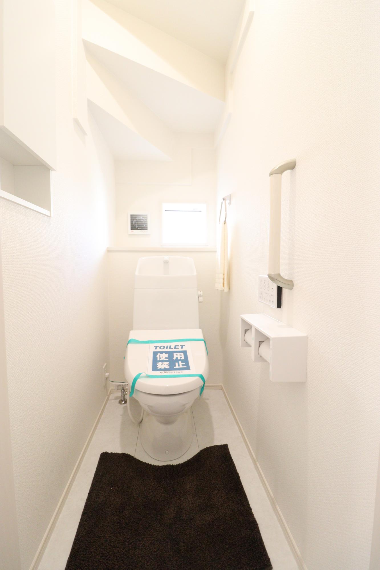 トイレ　1階　トイレットペーパーや清掃用具を収納できる壁収納(写真左側)が備わっています。