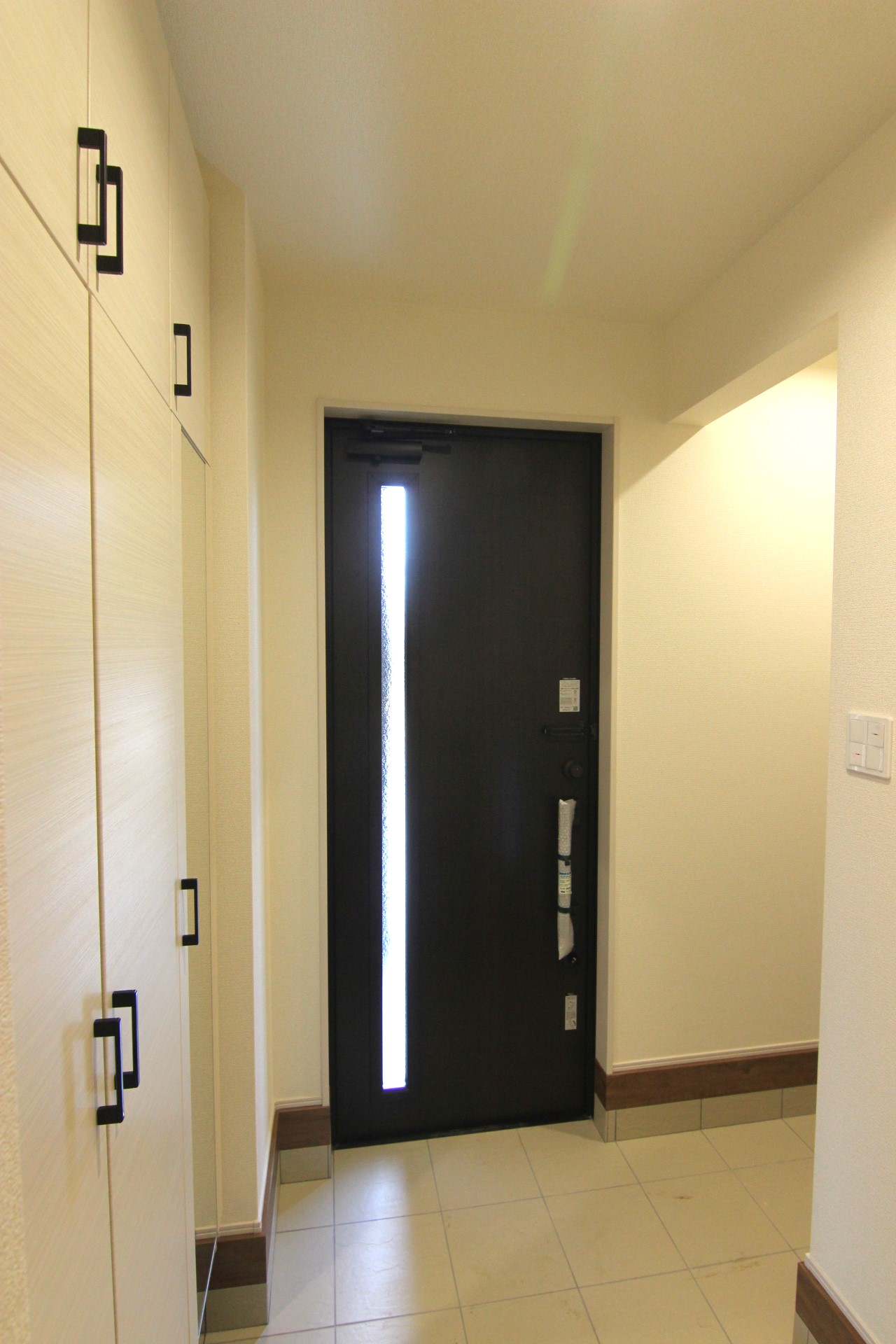 【2号棟玄関】　白の木目がおしゃれな玄関収納。玄関ドアは電子錠付きでスマホ操作もできます。(玄関ドア・収納は1・2号棟共通仕様)