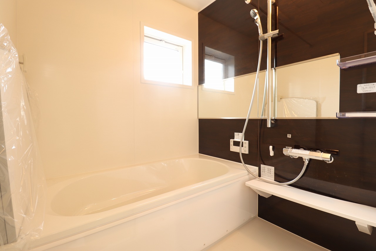 【3号棟/浴室】　ブラウンのアクセントパネルがシックな印象の浴室。落ち着いた雰囲気の中、1日の疲れをゆったりと癒すことができそうです。シャワーは高さ調節が自由自在のスライドバーを採用しています。