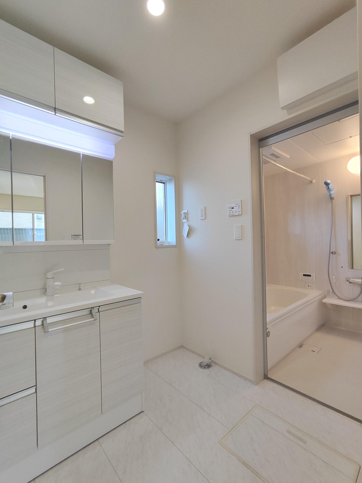 【2号棟】　ホワイトカラーでまとめられた洗面所は、横幅が900mmワイドの三面鏡付きで朝の身支度もラクラク。吊り戸もあり収納スペースにも困りません。