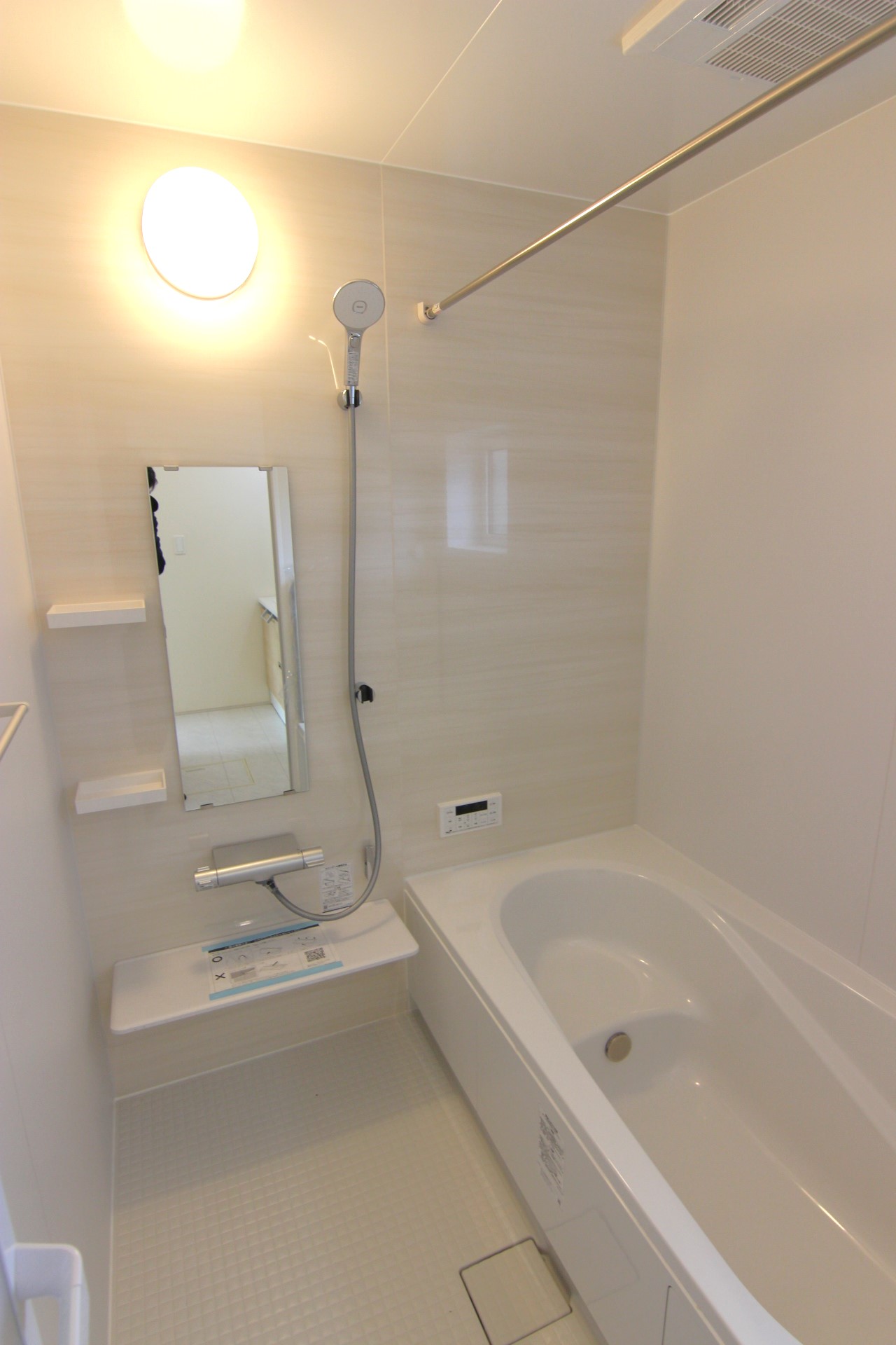 【2号棟:浴室】　白を基調とした、優しく淡い木目調の指し色がおしゃれな、明るい浴室。浴室暖房換気乾燥機付。浴槽は温かさが続くサーモバスS構造。