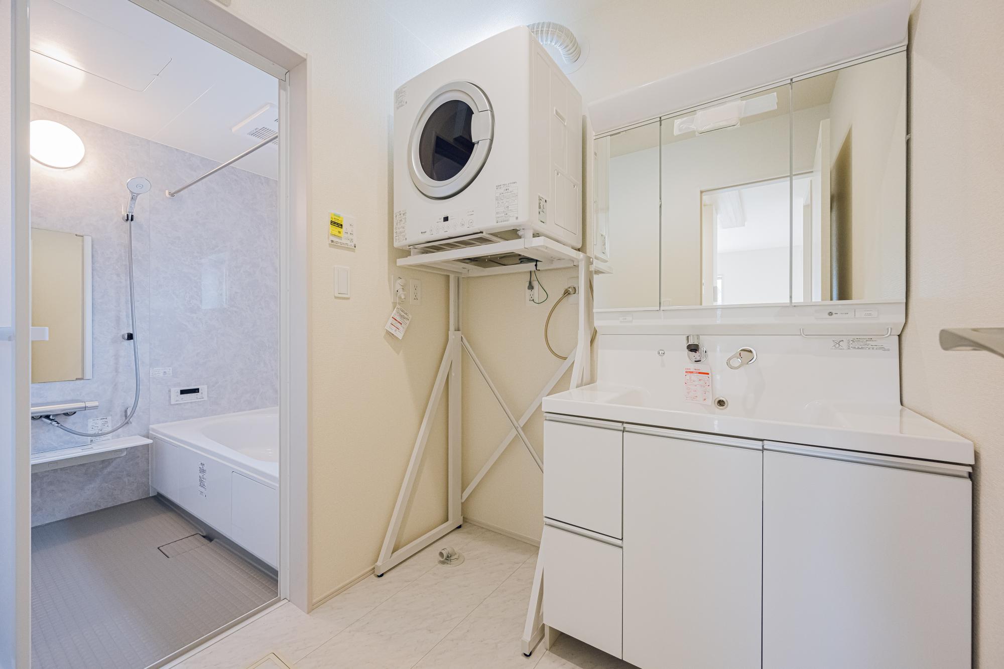 3号棟:洗面スペース　水ハネ軽減やコップ等の置き場として900ワイド洗面化粧台。 ガス衣類乾燥機は標準設置。