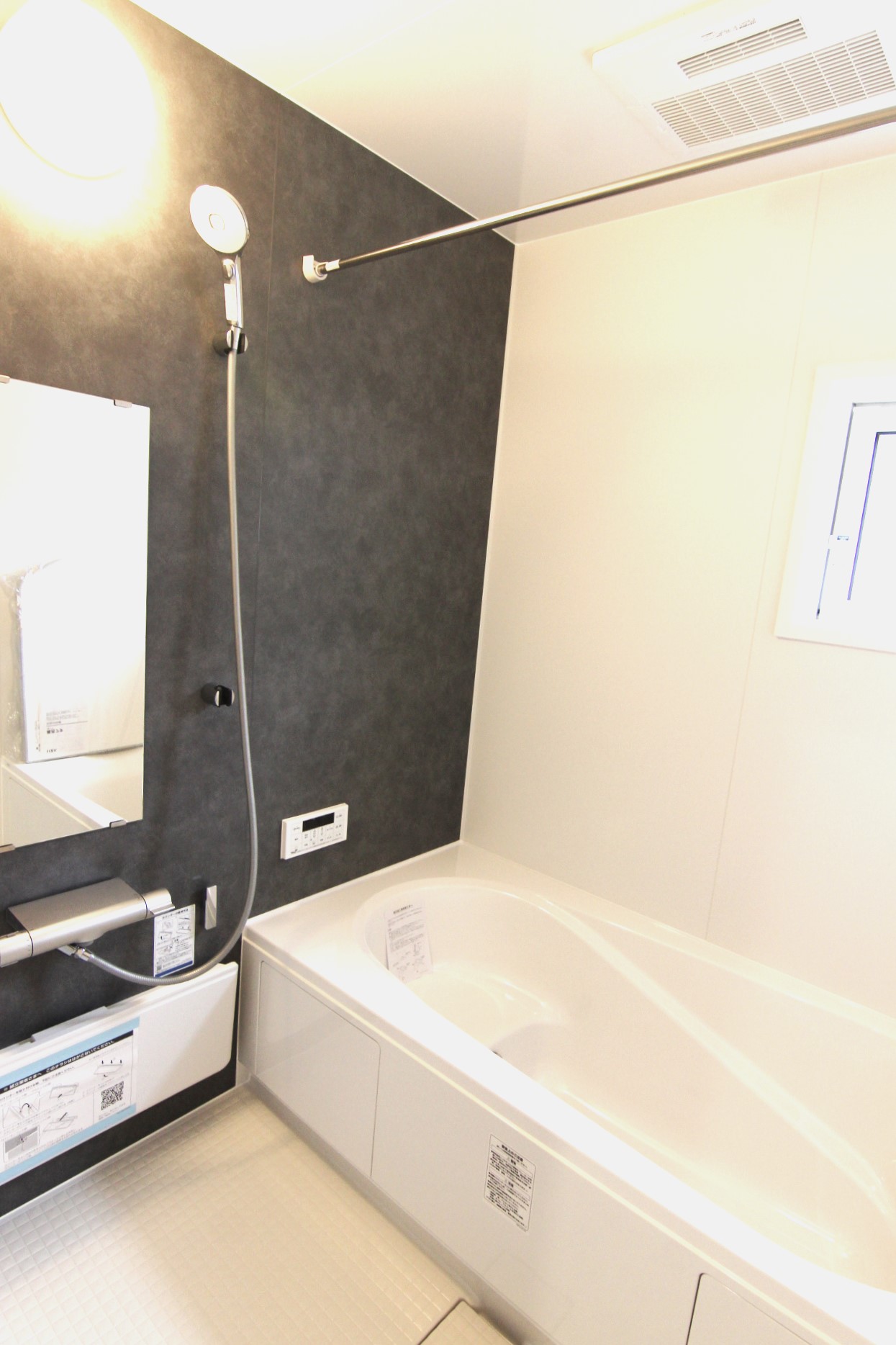 【浴室】　白を基調とし、モルティオダークの壁を一面に敷いたシックな雰囲気の浴室。浴室暖房換気乾燥機付で冬は温かく、雨の日のお洗濯も安心。浴槽は温かさが続くサーモバスS構造。
