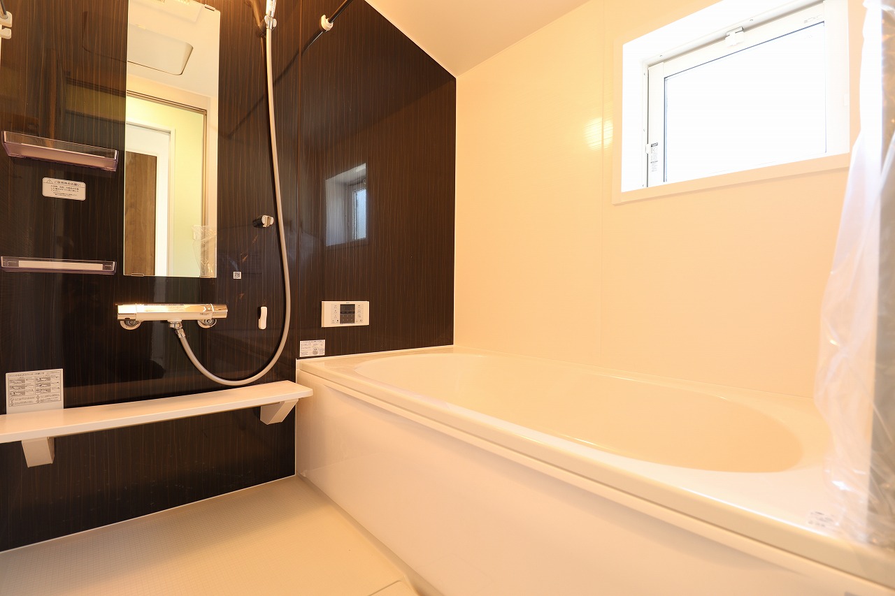 【8号棟/浴室】　ダークカラーのアクセントパネルを施したホテルライクな浴室です。浴室乾燥機が備わり、天候や時間帯に関係なく、洗濯物が気持ちよく乾かせます。