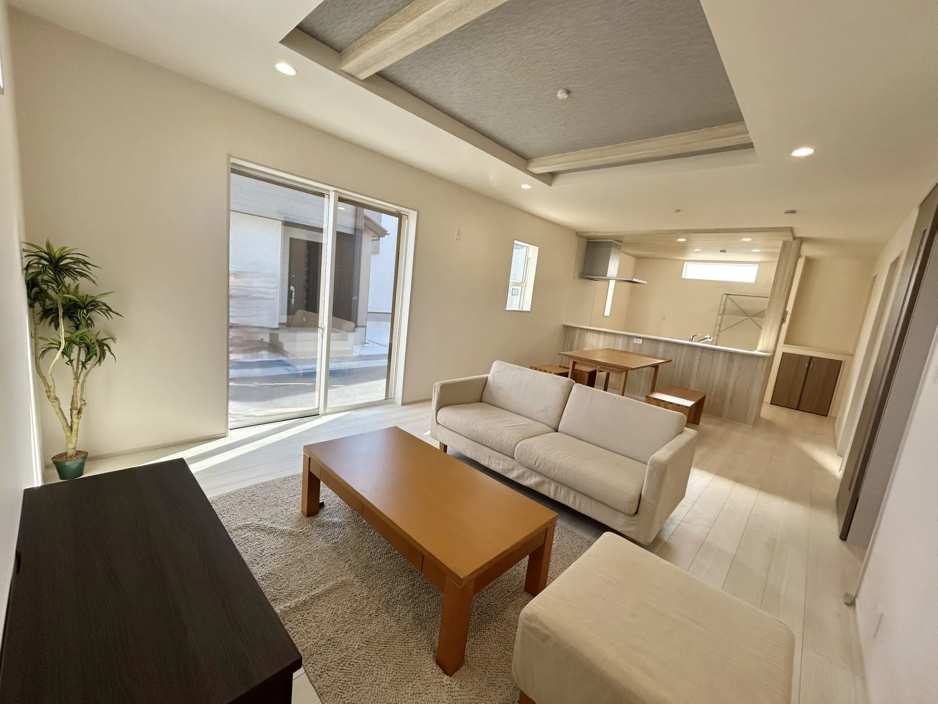 【①号棟】キッチン部分と折上天井の梁部分に同一の木目調のアクセントクロスでリビングに統一感を出しました