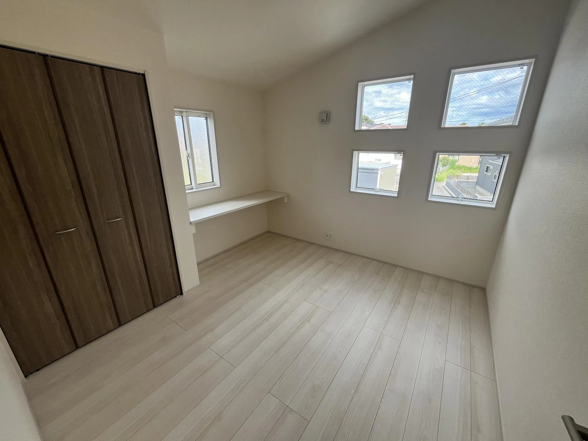 【①号棟】開放感を演出する勾配天井を採用した5.25帖の洋室。カウンター付きなので書斎やお子様の学習スペースにもぴったりです。