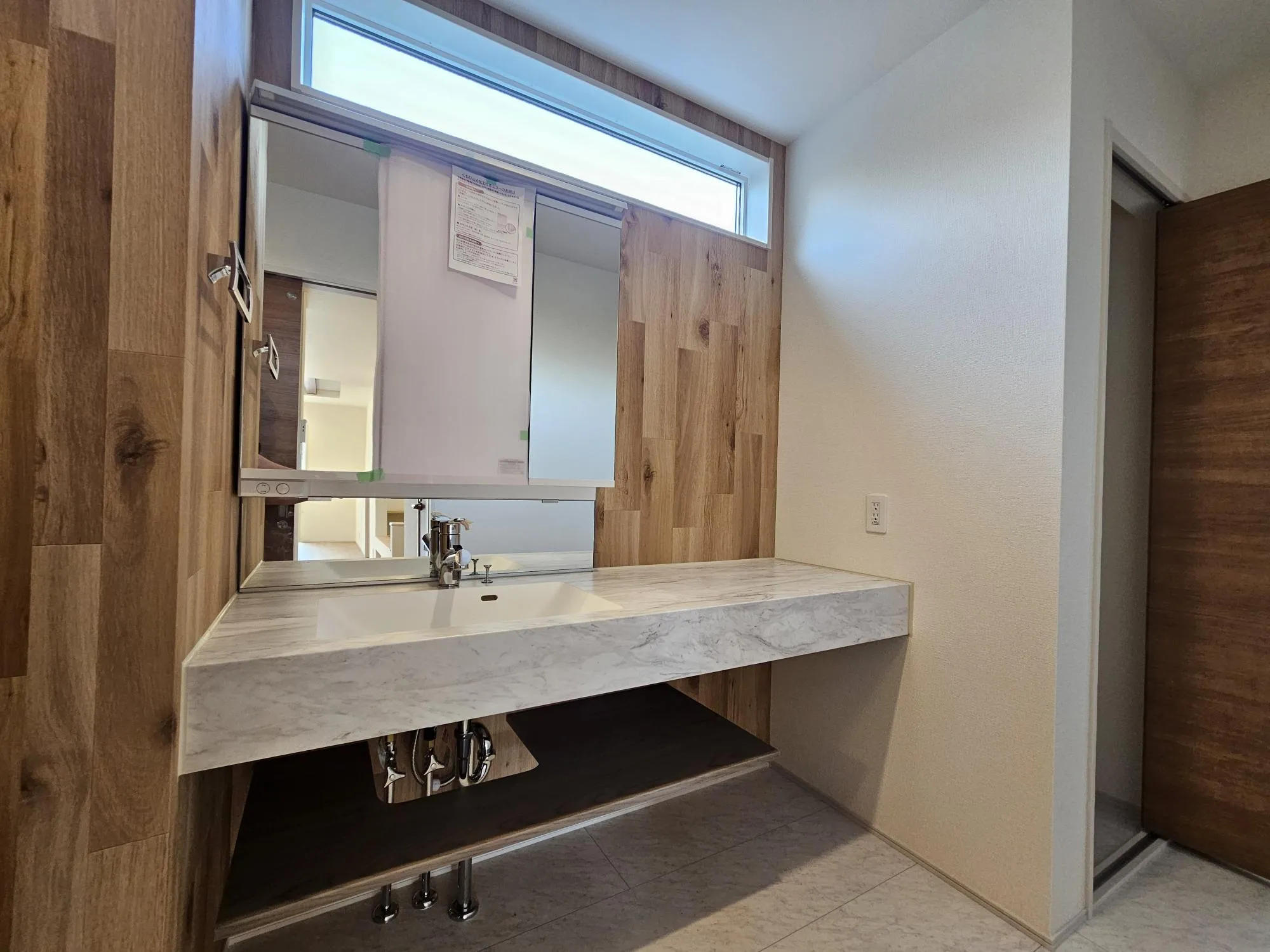 1号棟　オープンサニタリー
シンプルなワイド仕様の洗面化粧台です。アクセントクロスにより注文住宅のようなオシャレな空間となっております!