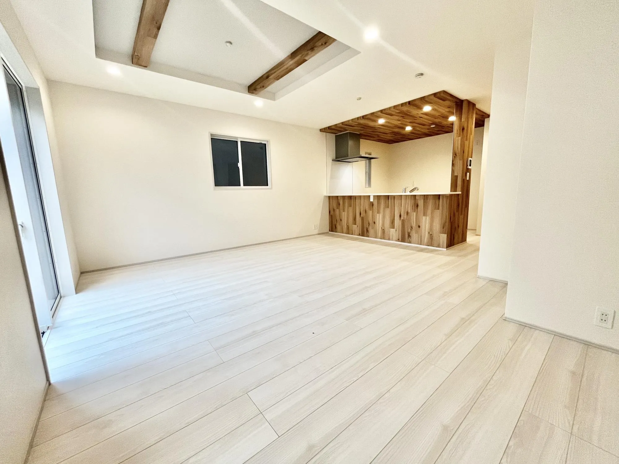 木目調のポップアップキッチンは天井デザインで空間を仕切り、メリハリを演出。折上天井の化粧梁も同じカラーで統一感をもたせています【2号棟】