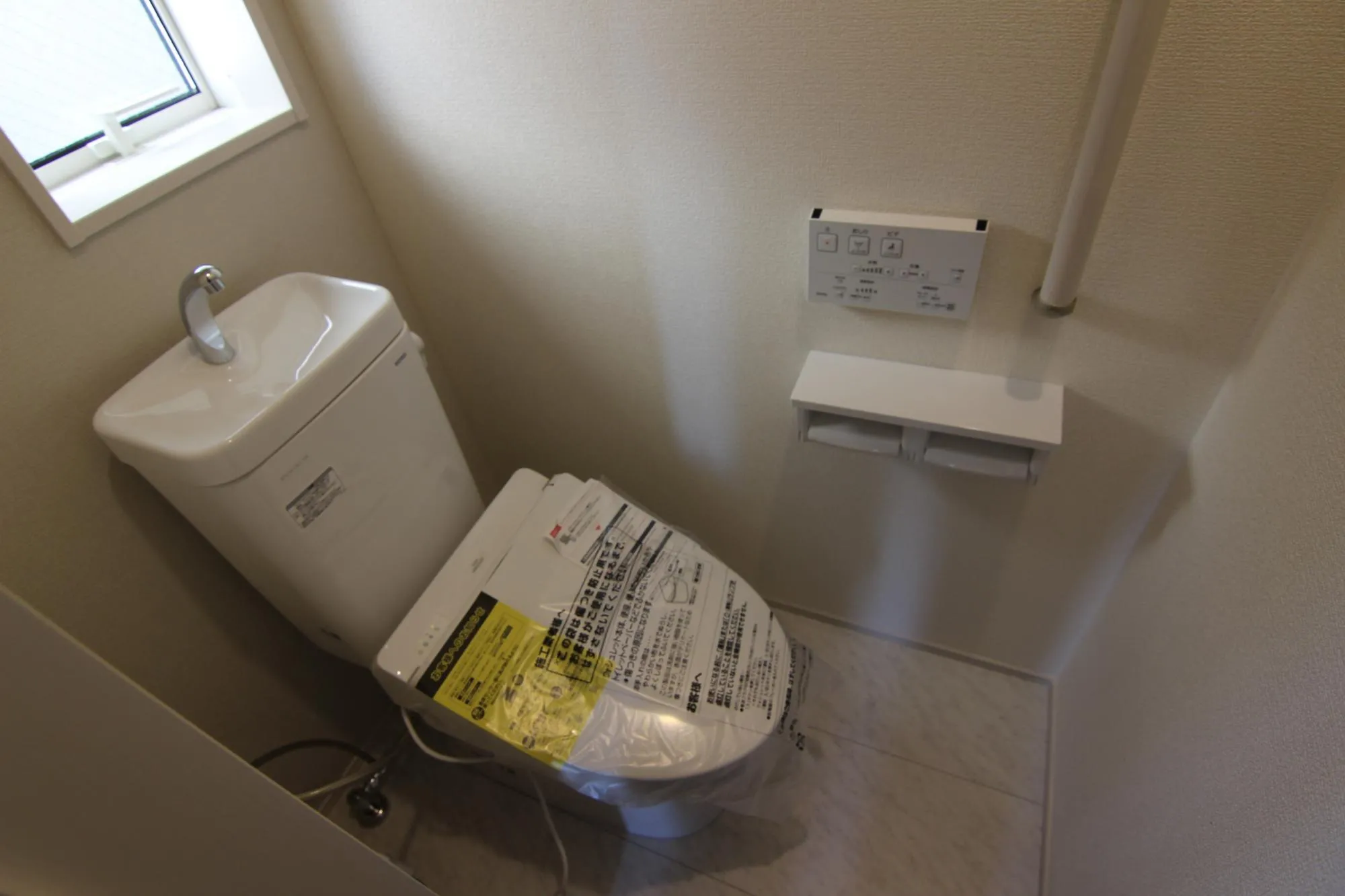 リモコン付きウォシュレットの1階トイレ　2連紙巻き器、手すり、タオル掛け、トイレ収納は標準装備。開口部があるので明るく清潔感が溢れています。