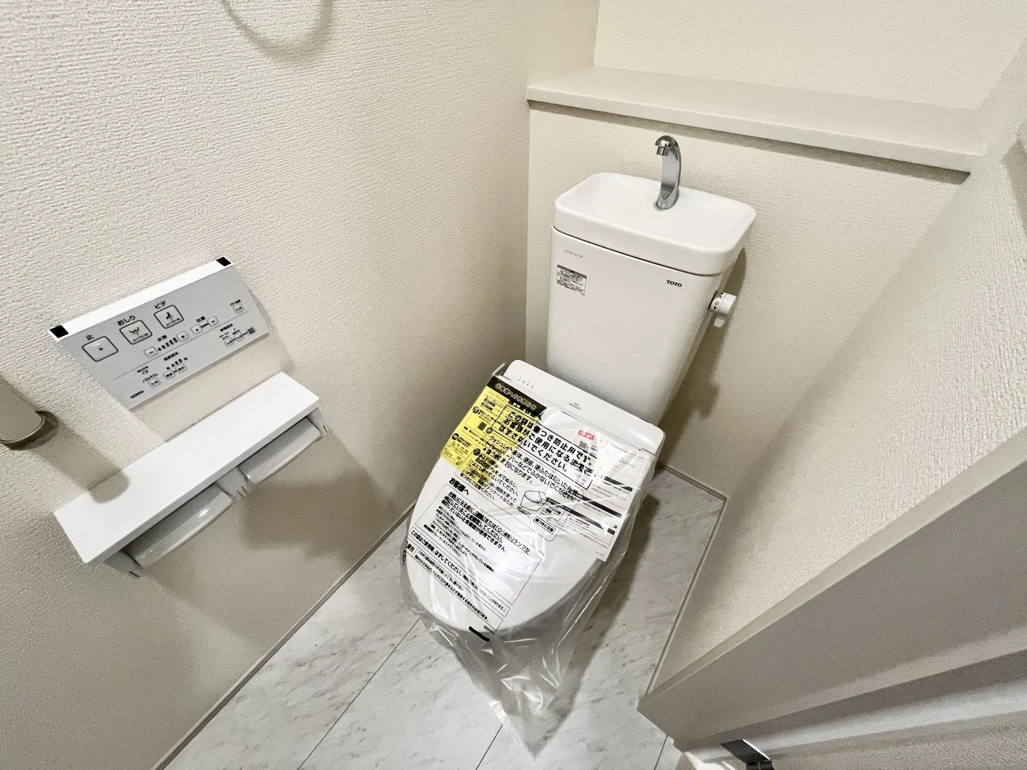 いつでも快適に使える温水洗浄便座を設置。リモコンが壁面に設置されているのが使っていて便利を実感【2号棟】