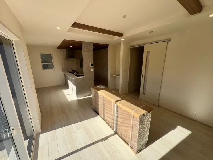 キッチン部分と折上天井の梁部分に同一の木目調のアクセントクロスでリビングに統一感を出しました。※完成前の写真です【3号棟】