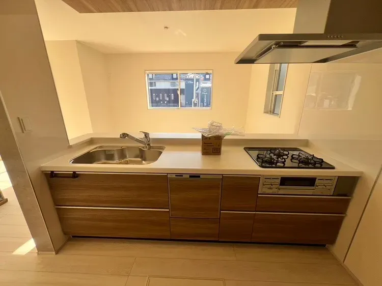 三口コンロ・食洗機付きのシステムキッチン。シンクは蛇口一体型浄水器、浄水・原水の切り替えがワンタッチ。【3号棟】