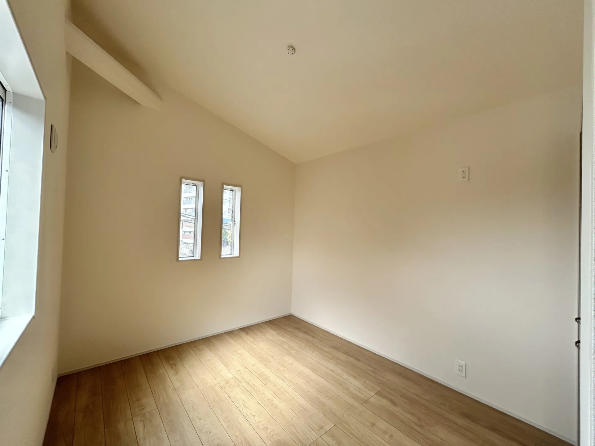 【②号棟】勾配天井のある洋室。天井を屋根形状高くすることでお部屋を広く感じさせます。