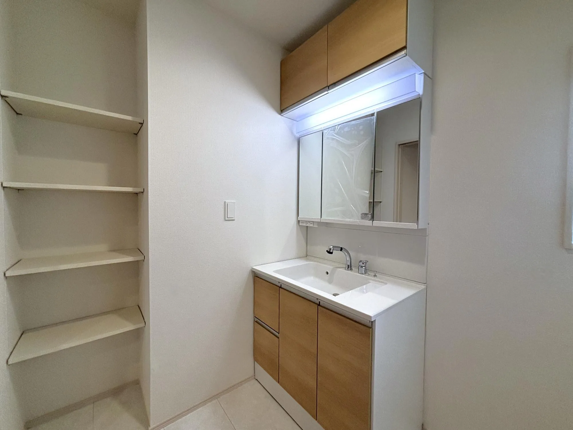 【洗面】三面鏡付の洗面台。洗面室にはタオルや洗剤、日用品をすっきりしまえる収納を採用。可動棚で高さを自由に調整でき、家族のライフスタイルに合わせて使いやすくカスタマイズできます。