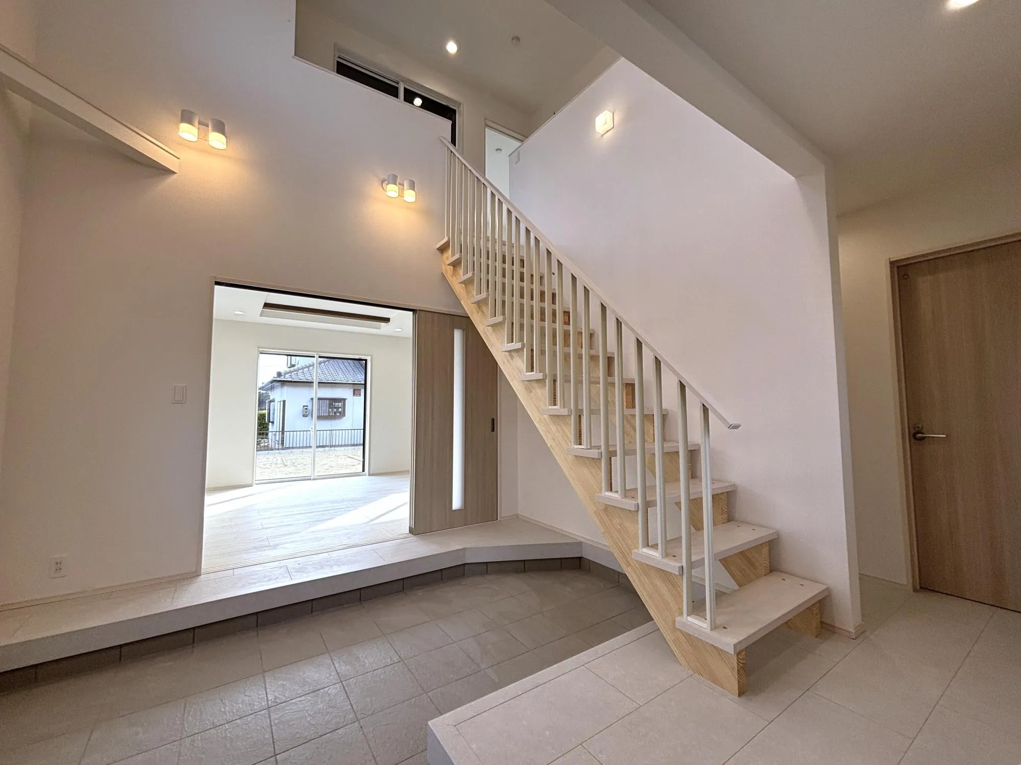 【玄関(2号棟)】軽やかなデザインで明るい空間を実現するおしゃれなデザイン階段を採用。