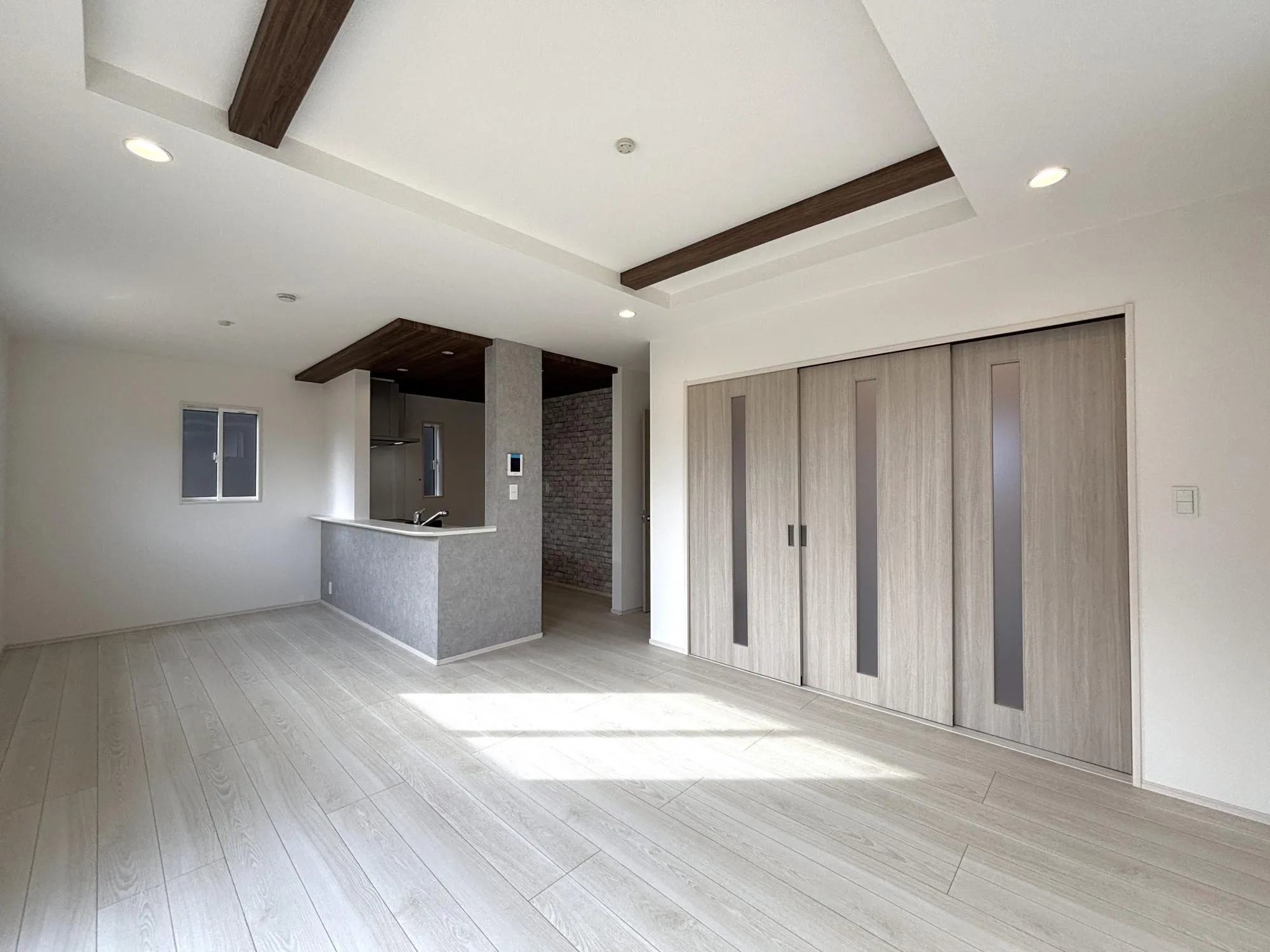 【リビング(2号棟)】折上天井とポップアップ天井にシックなアクセントクロスをつかい、落上質で落ち着いた室内空間に。