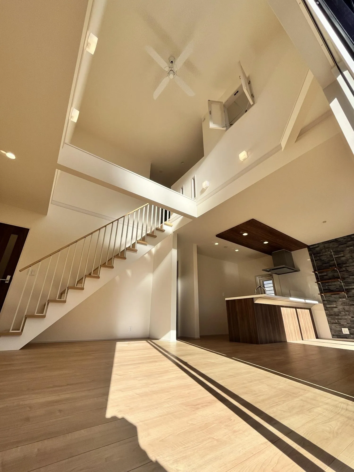 大きな吹抜けとたっぷりの陽光が広がるリビング。家族が集まり、会話が弾む開放的な空間です。