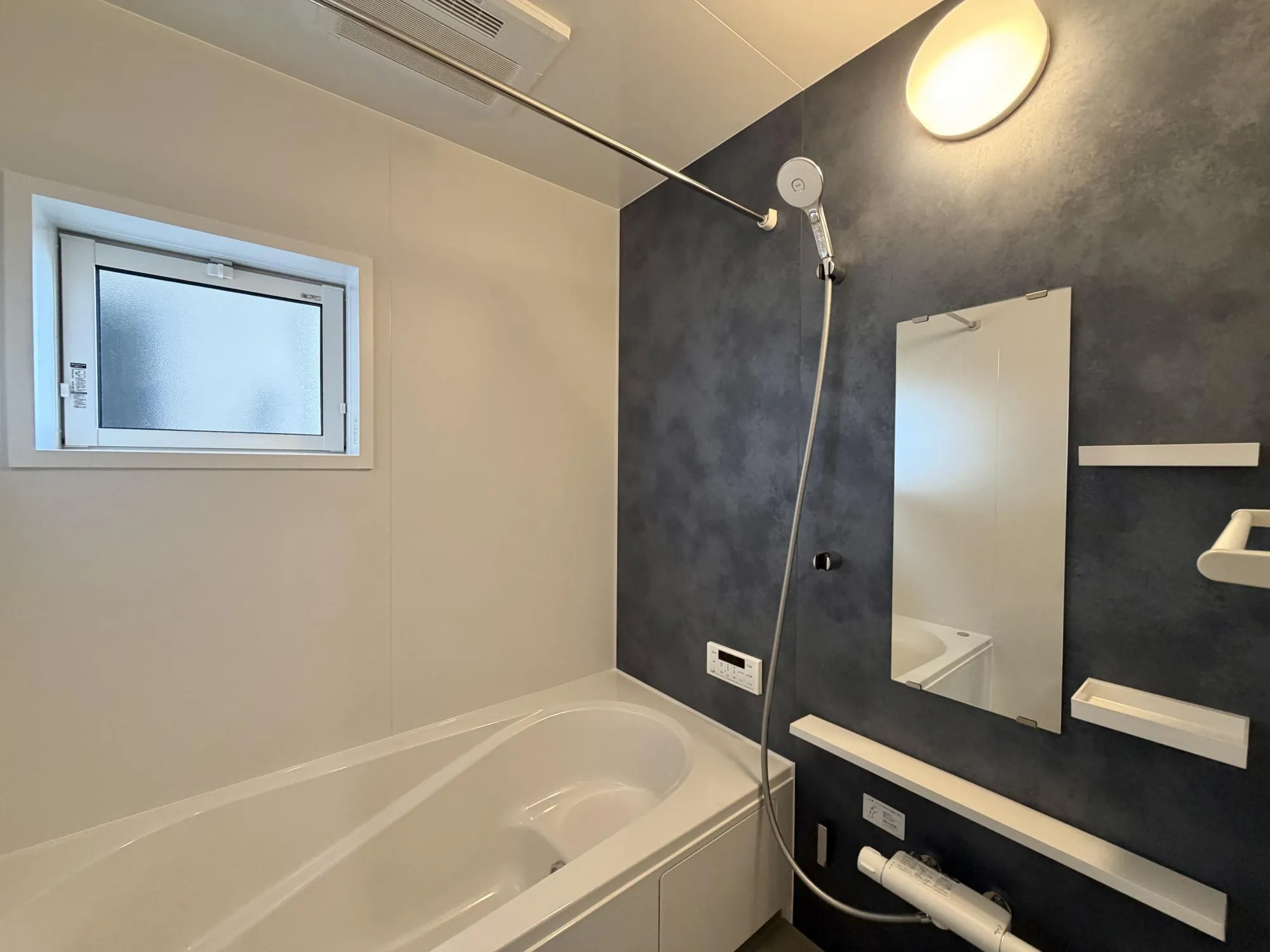 【浴室1号棟】シックな色合いのアクセントパネルを採用。落ち着きのある雰囲気で疲れた体を癒します。