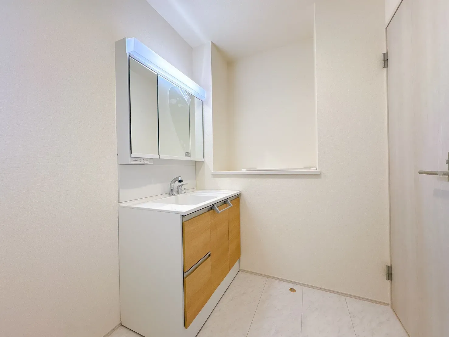 【脱衣所】身支度やヘアセットに便利な三面鏡タイプの洗面化粧台を設置。明るくすっきりとしたデザインで、毎日の身支度が快適に行える洗面所です。