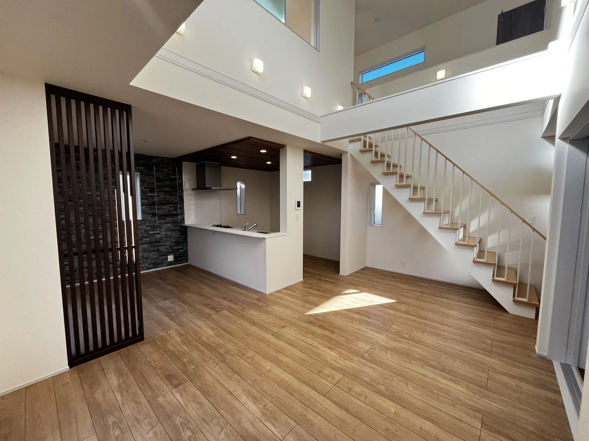 大きな窓から差し込む陽光が、リビング全体を明るく照らします。広々とした空間で、家族の会話も弾む毎日を。