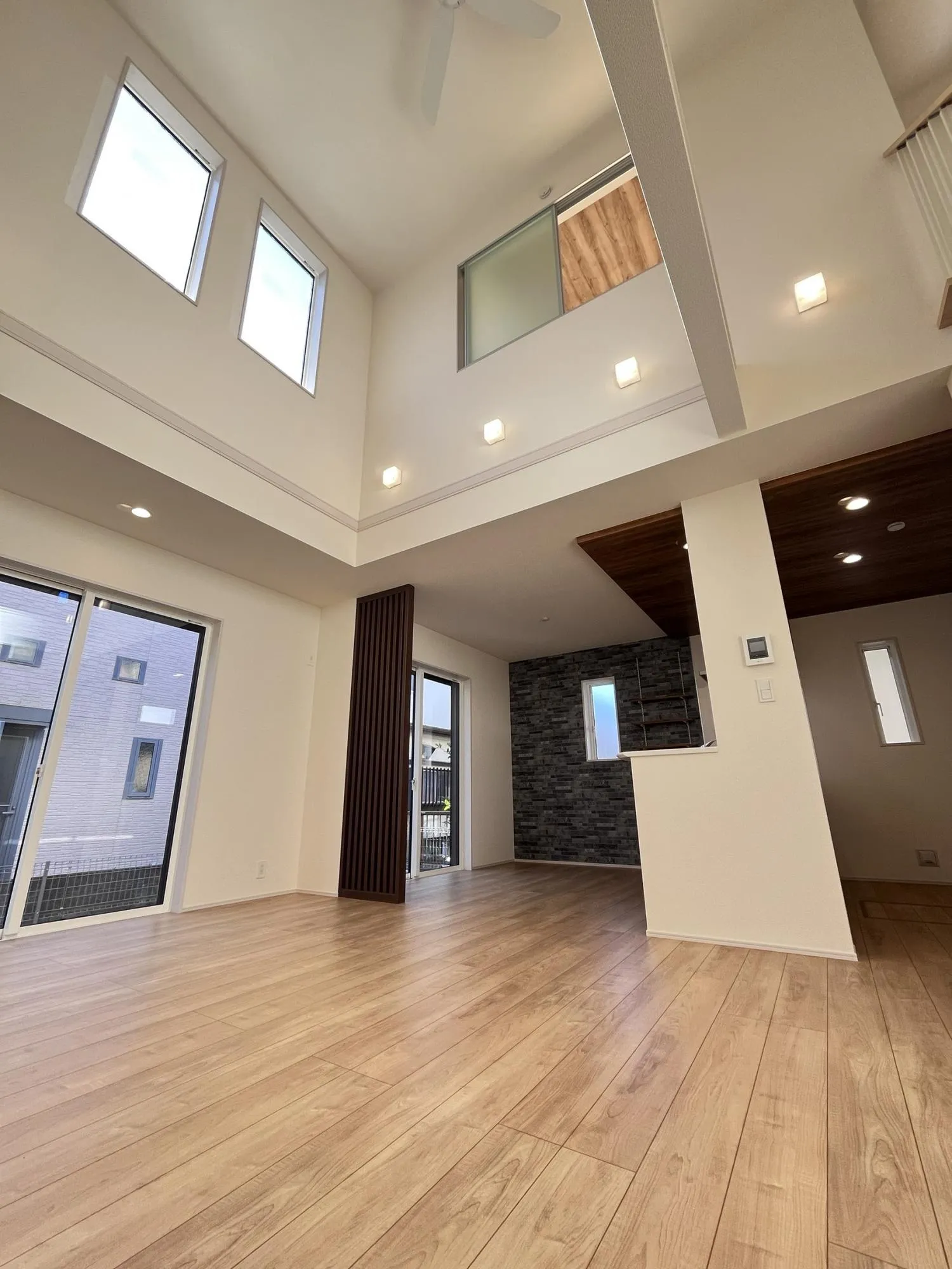 大きな吹抜けとたっぷりの陽光が広がるリビング。家族が集まり、会話が弾む開放的な空間です。