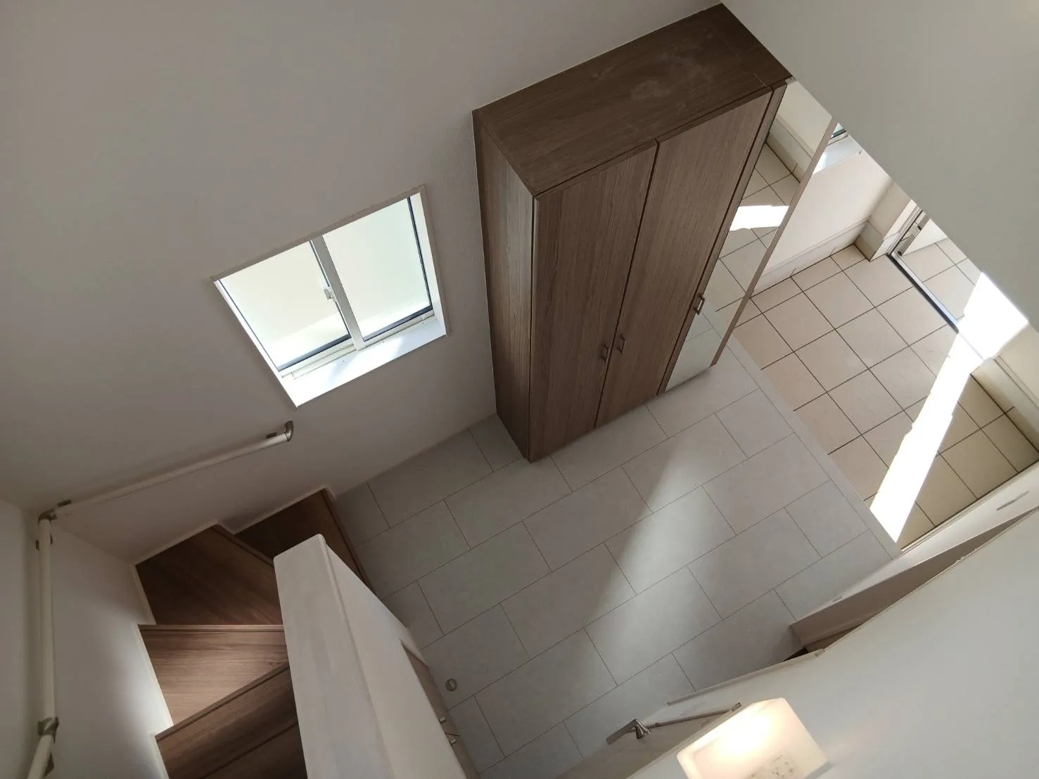 【玄関吹抜】玄関に吹抜を設け、扉を開けた瞬間に広がる開放的な空間。自然光がやさしく差し込み、住まい全体を明るく迎える印象的な玄関です。