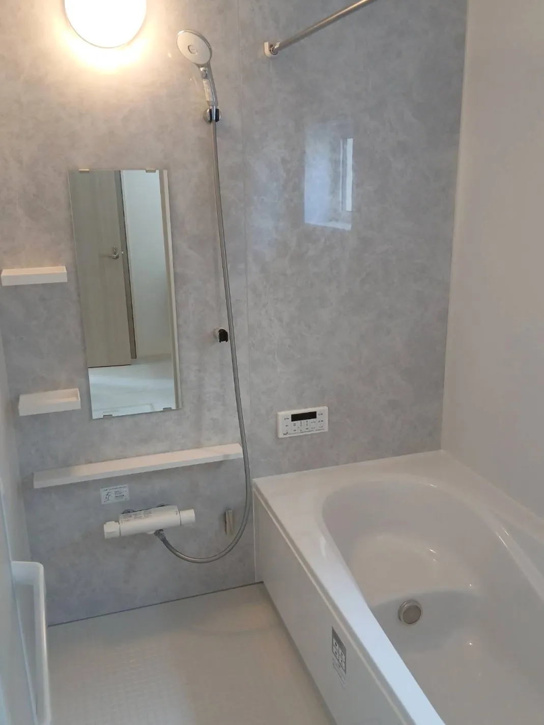 【浴室】グレーのアクセントパネルで仕上げ、明るく清潔感のある空間に。シンプルで飽きのこないグレーが、清潔感と高級感を両立。