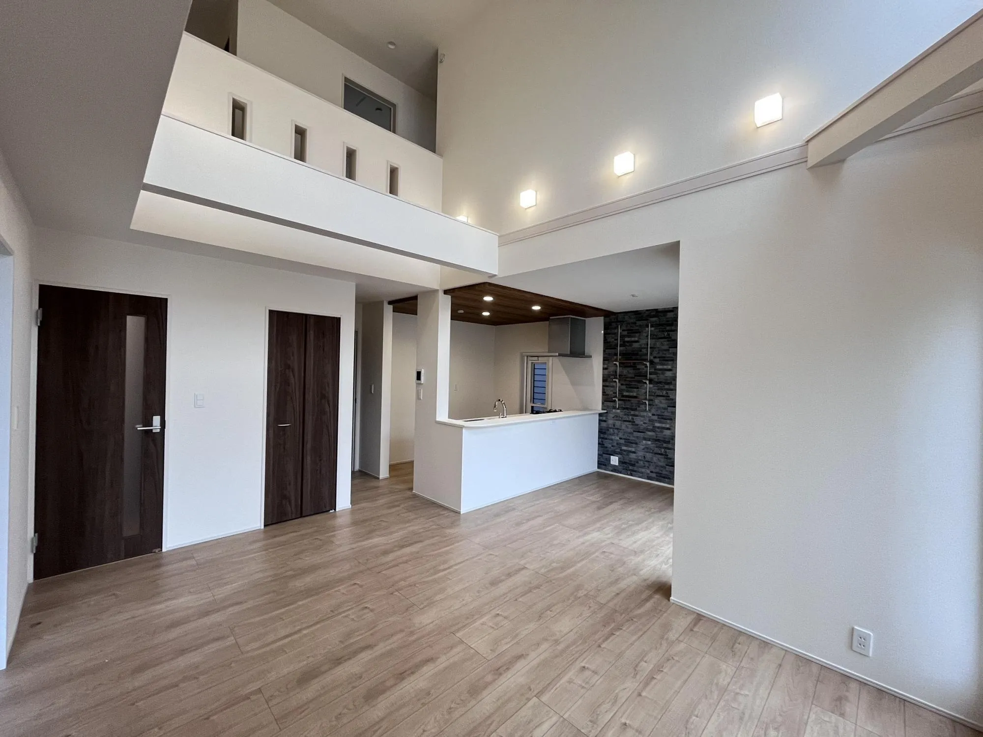 大きな吹抜けとたっぷりの陽光が広がるリビング。家族が集まり、会話が弾む開放的な空間です。