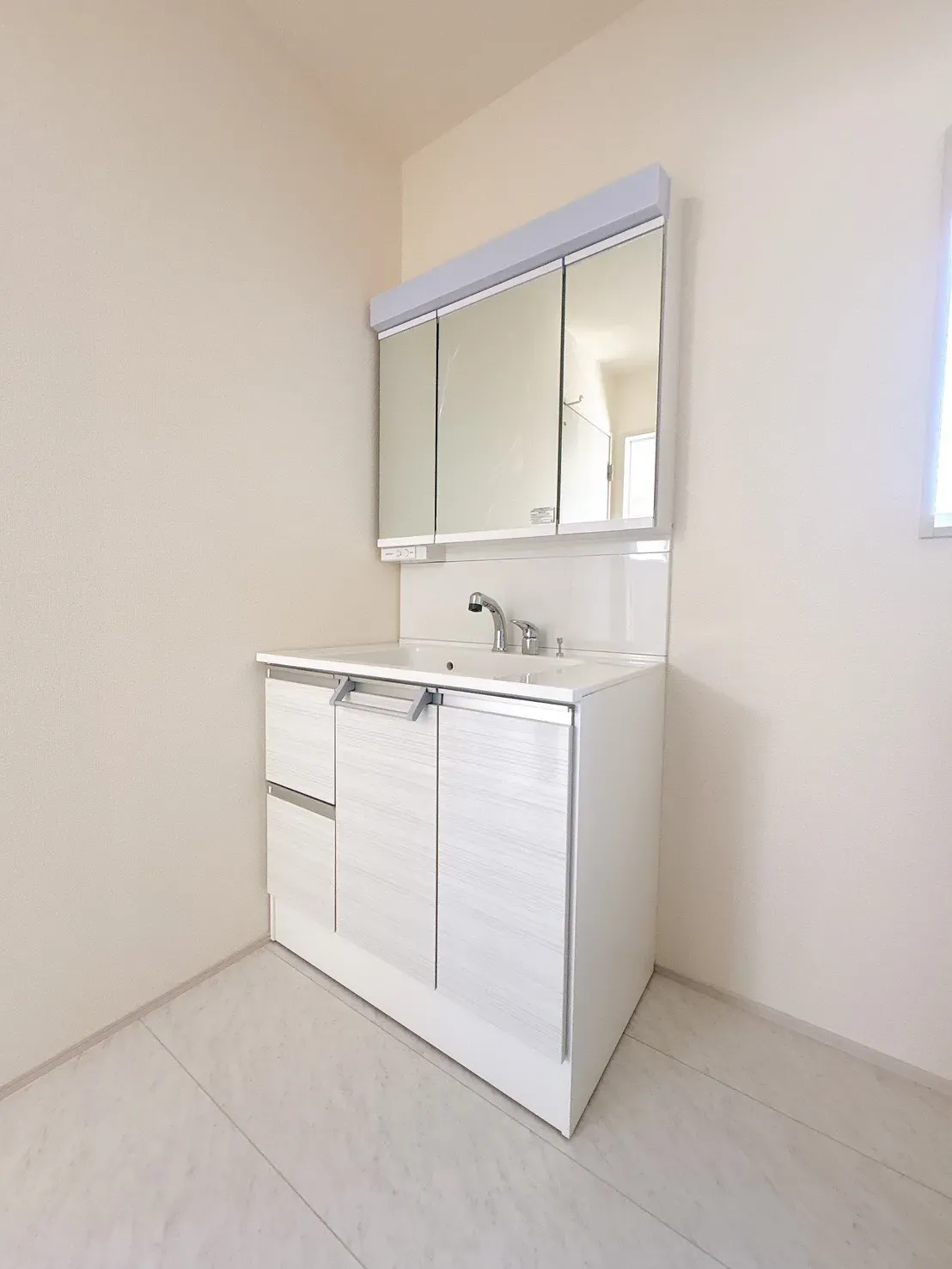 【1号棟脱衣場】身支度やヘアセットに便利な三面鏡タイプの洗面化粧台を設置。洗面室は玄関からLDKへの動線上に配置しており、帰宅時の手洗いもスムーズに行えます。