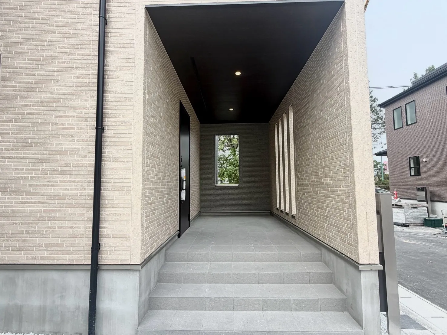 【エントランス:7号棟】玄関外には広々としたスペースと屋根を採用し、雨が降っていても落ち着いて荷物の出し入れが可能に。